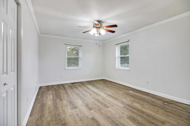 spare room with a wealth of natural light, crown molding, and light hardwood / wood-style flooring