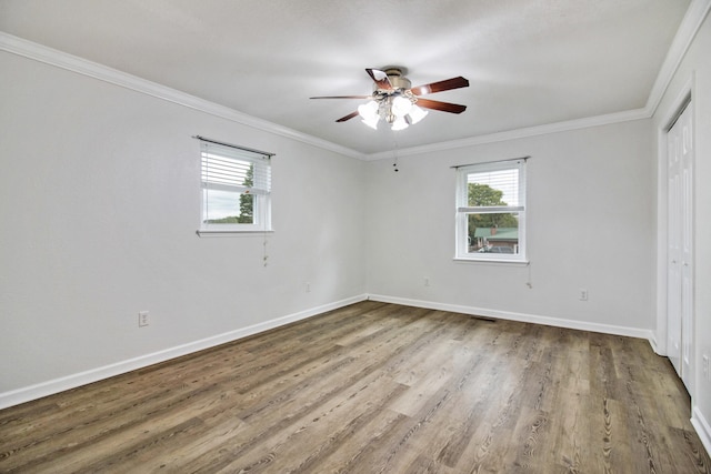 empty room featuring hardwood / wood-style floors, ceiling fan, and crown molding