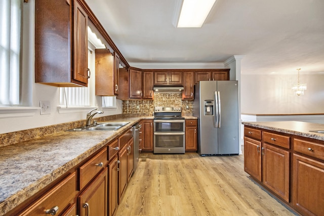 kitchen featuring backsplash, sink, a notable chandelier, light hardwood / wood-style floors, and stainless steel appliances