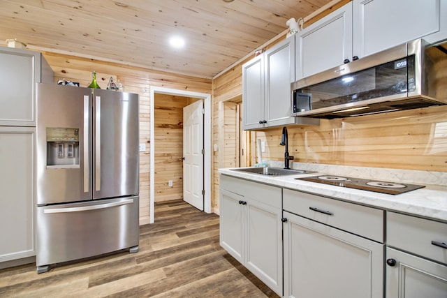 kitchen with wood walls, sink, wood-type flooring, stainless steel appliances, and wood ceiling