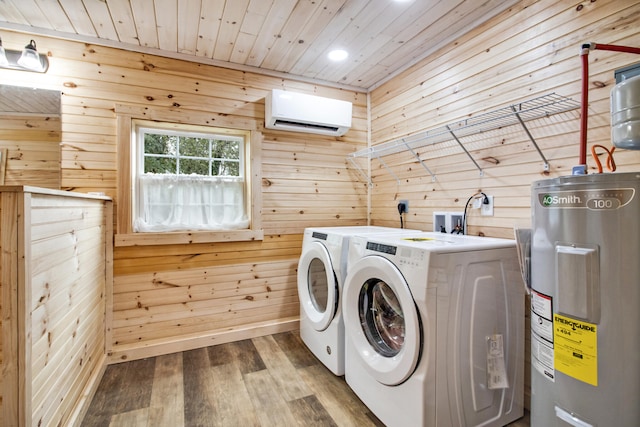 laundry room featuring an AC wall unit, electric water heater, wood walls, and independent washer and dryer