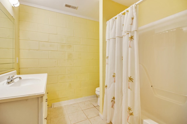 full bathroom with tile patterned floors, vanity, toilet, and shower / bath combo with shower curtain