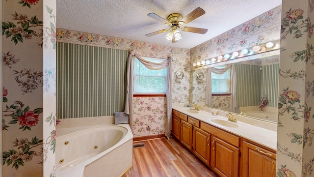 bathroom featuring vanity, a bathing tub, ceiling fan, a wealth of natural light, and wood-type flooring