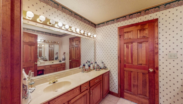 bathroom with tile patterned flooring, vanity, and a textured ceiling