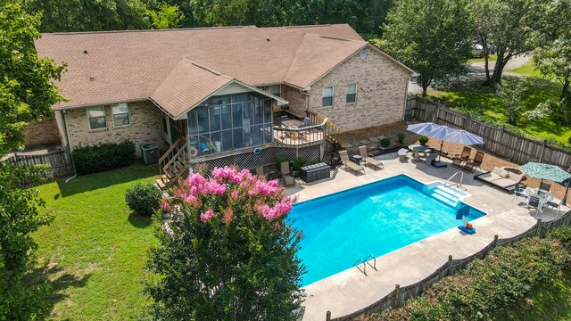 view of pool with outdoor lounge area, a sunroom, central AC unit, and a yard