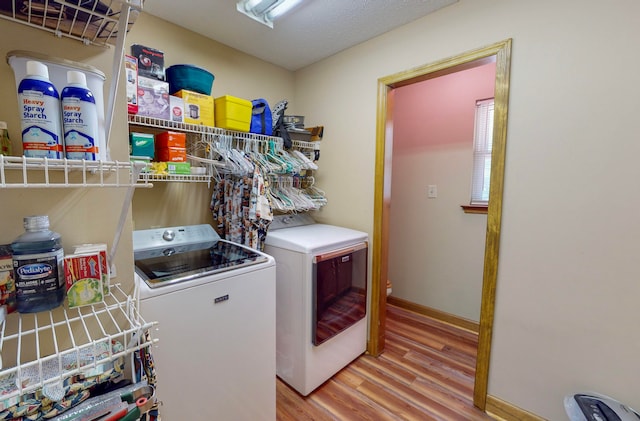 washroom featuring separate washer and dryer and light hardwood / wood-style floors