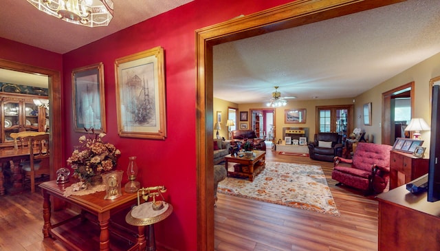 interior space featuring hardwood / wood-style flooring, a textured ceiling, and a chandelier