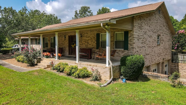 rear view of property featuring covered porch, a garage, and a lawn