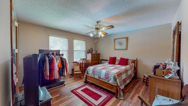 bedroom with ceiling fan, light hardwood / wood-style floors, and a textured ceiling