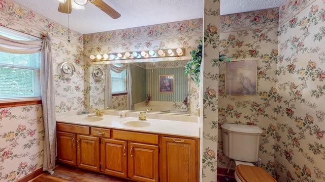 bathroom with vanity, a textured ceiling, ceiling fan, hardwood / wood-style flooring, and toilet