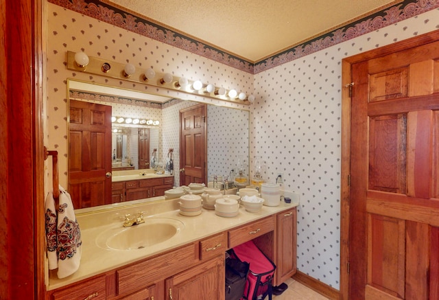 bathroom with tile patterned floors, vanity, and a textured ceiling