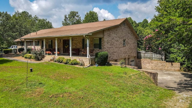 single story home featuring a front yard, a porch, and a garage