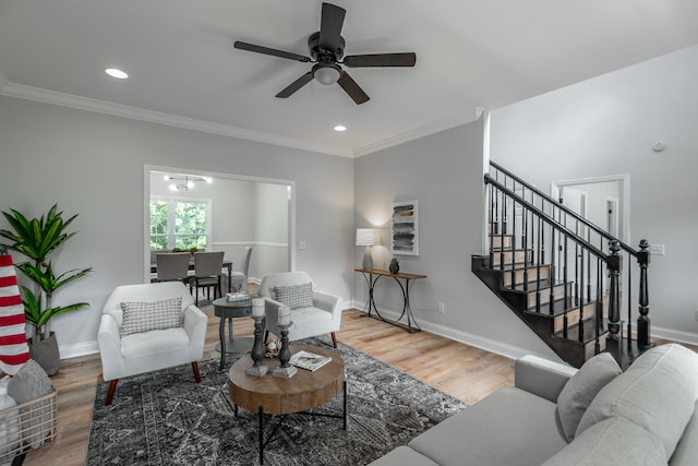 living room featuring wood-type flooring, ceiling fan, and crown molding