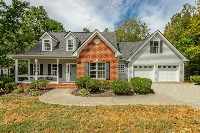 view of front of property featuring a porch, a garage, and a front lawn