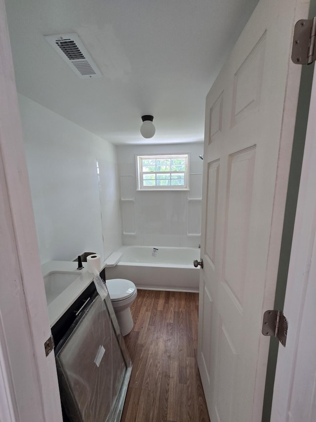 full bathroom with vanity, hardwood / wood-style flooring, shower / tub combination, and toilet