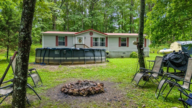 1426 Nebo Rd, Ten Mile, TN 37880 - back of property with a fire pit, a covered pool, a lawn, crawl space, and metal roof
