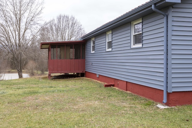 view of home's exterior with a lawn and a sunroom