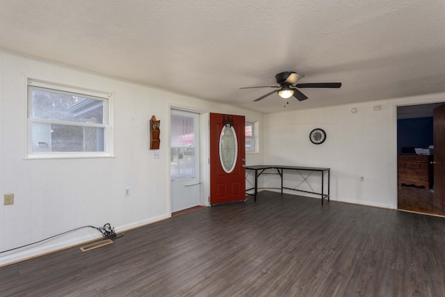 foyer entrance with ceiling fan, dark hardwood / wood-style flooring, and a textured ceiling