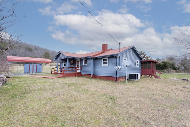 back of property featuring central AC, a yard, a wooden deck, and a carport