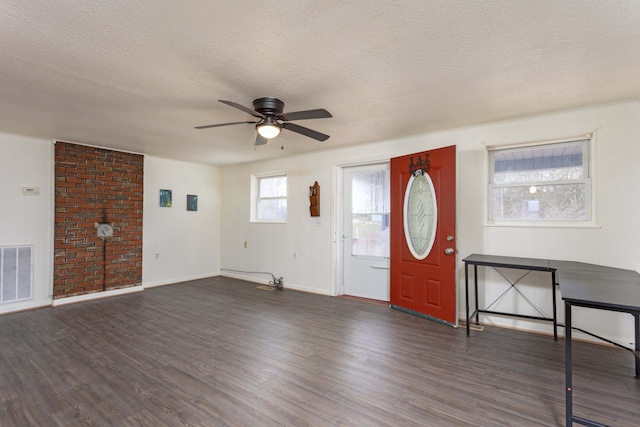 foyer with ceiling fan, a textured ceiling, and dark wood-type flooring