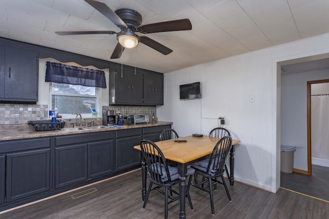 dining area featuring ceiling fan, dark hardwood / wood-style flooring, and sink