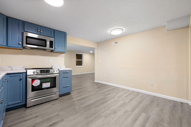 kitchen with a textured ceiling, light hardwood / wood-style floors, blue cabinets, and stainless steel appliances