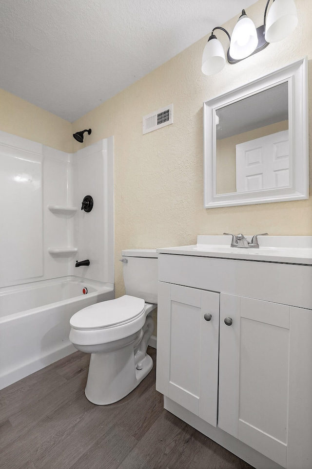 full bathroom featuring hardwood / wood-style floors, vanity, a textured ceiling, and toilet