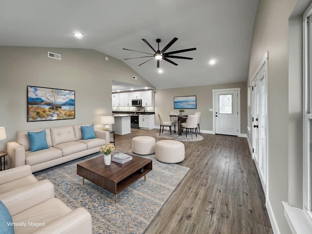 living room with lofted ceiling, hardwood / wood-style flooring, and ceiling fan