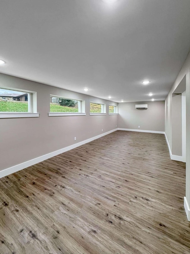 spare room with an AC wall unit and light hardwood / wood-style flooring