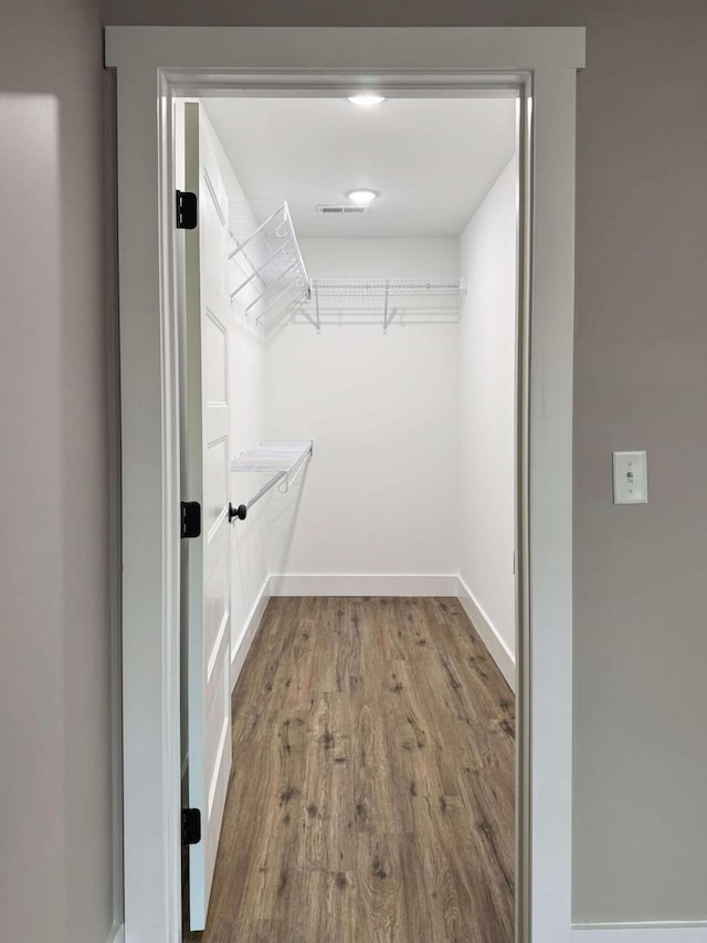 walk in closet with hardwood / wood-style floors