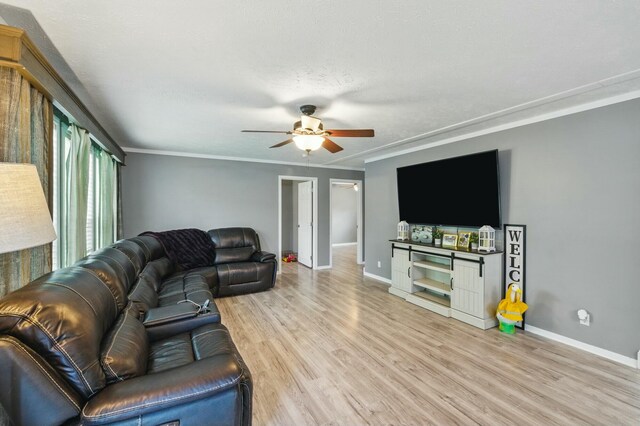 living area with ornamental molding, ceiling fan, wood finished floors, and baseboards