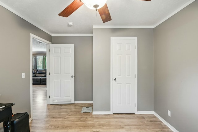 bedroom featuring ornamental molding, light wood-style flooring, a ceiling fan, and baseboards