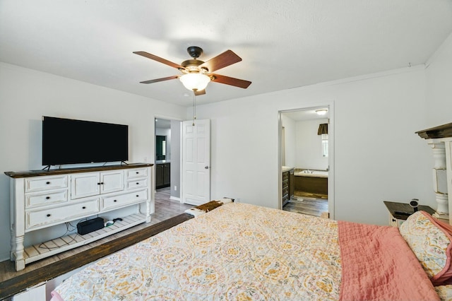 bedroom featuring wood finished floors, ensuite bath, a ceiling fan, and baseboards