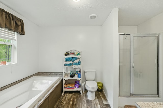 bathroom with toilet, wood finished floors, a garden tub, and a shower stall