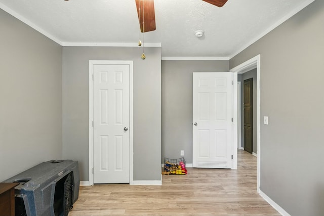 bedroom featuring crown molding, light wood finished floors, baseboards, and a ceiling fan