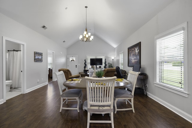 dining space with dark hardwood / wood-style floors, vaulted ceiling, a wealth of natural light, and a chandelier