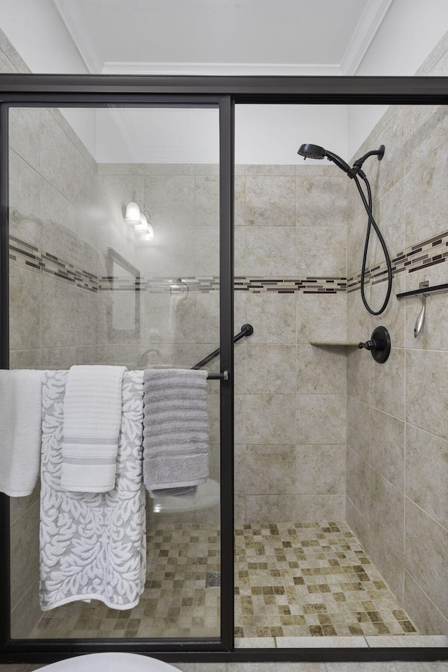 bathroom with a shower with door and ornamental molding