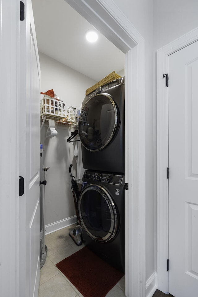 laundry room with stacked washing maching and dryer and light tile patterned flooring