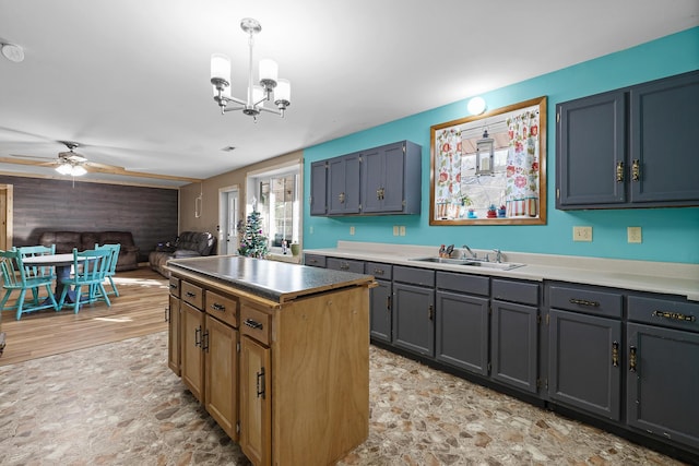 kitchen with ceiling fan with notable chandelier, decorative light fixtures, and sink