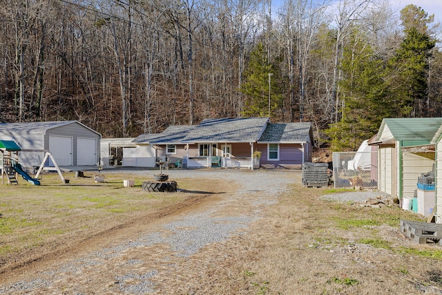 view of front of property with a porch, a storage unit, a playground, and a front lawn