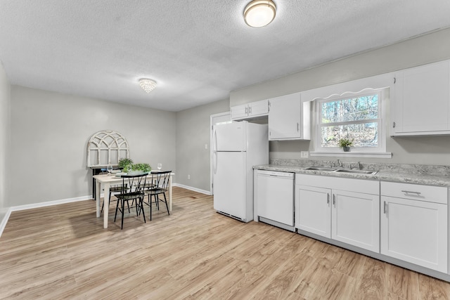 kitchen featuring light wood-style floors, white cabinetry, a sink, white appliances, and baseboards