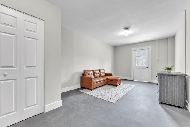 sitting room featuring visible vents, baseboards, and concrete flooring