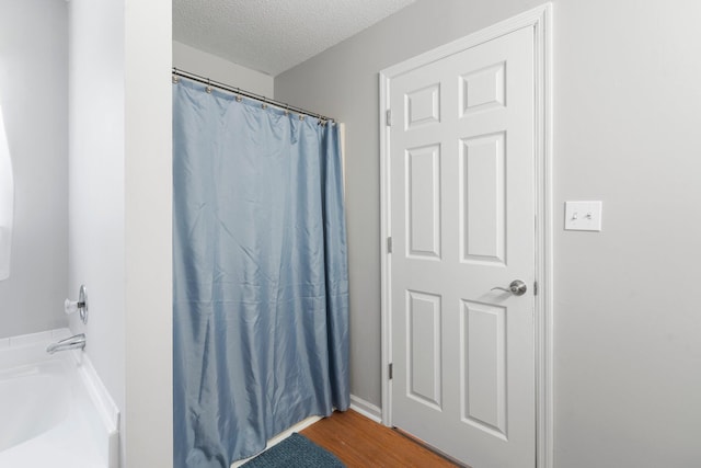 7701 Diamondhead Dr, Ooltewah, TN 37363 - full bath with wood finished floors, a textured ceiling, and curtained shower