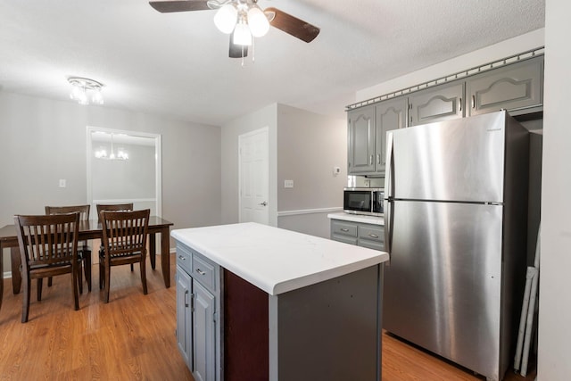 7701 Diamondhead Dr, Ooltewah, TN 37363 - kitchen with stainless steel appliances, gray cabinetry, a ceiling fan, light countertops, and light wood finished floors