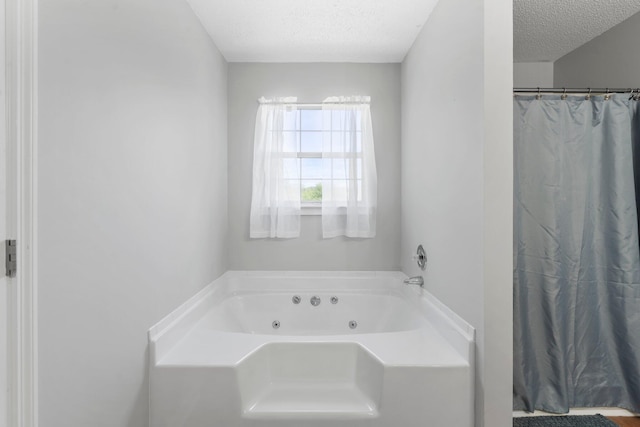 7701 Diamondhead Dr, Ooltewah, TN 37363 - full bath featuring a textured ceiling, a jetted tub, and a shower with curtain
