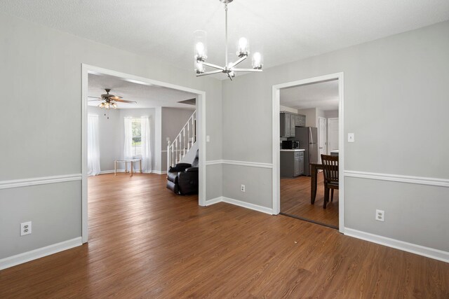 7701 Diamondhead Dr, Ooltewah, TN 37363 - empty room featuring a chandelier, dark wood-style flooring, ceiling fan, and stairs