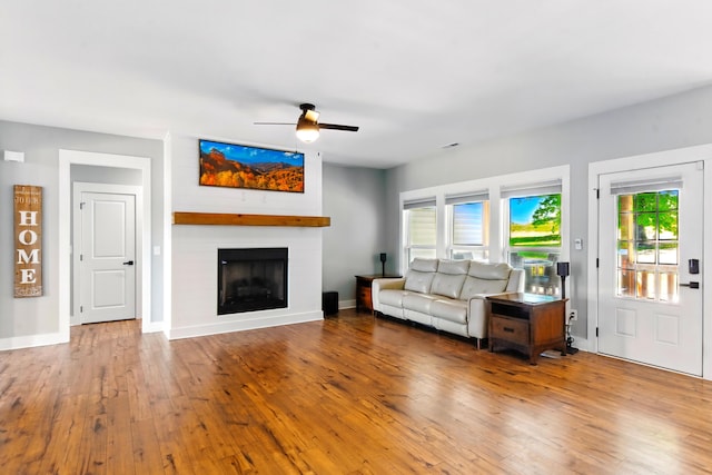 1786 Welcome Valley Rd, Benton, TN 37307 - living area featuring baseboards, a large fireplace, ceiling fan, and wood-type flooring