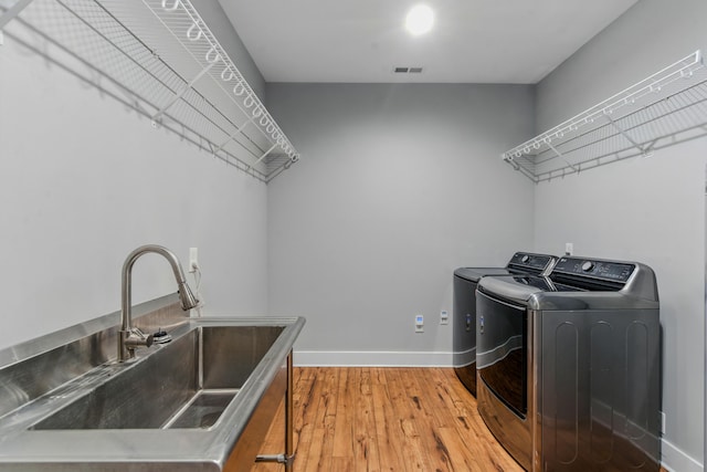 1786 Welcome Valley Rd, Benton, TN 37307 - laundry area with a sink, baseboards, washer and dryer, wood finished floors, and laundry area