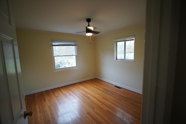 spare room featuring hardwood / wood-style flooring, plenty of natural light, ceiling fan, and ornamental molding