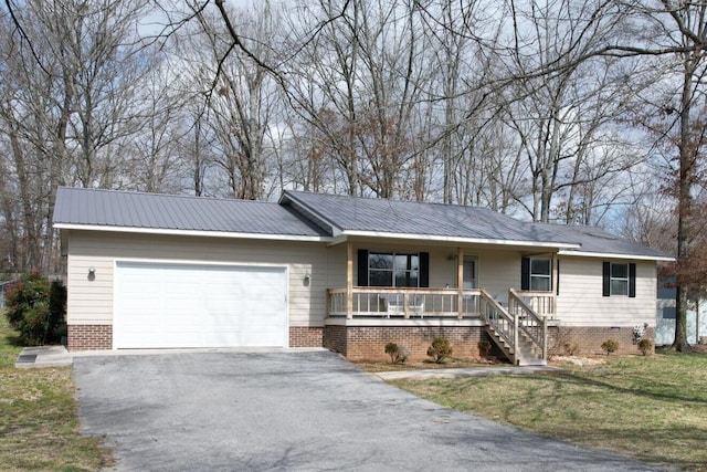 ranch-style home featuring a porch, a front yard, an attached garage, and aphalt driveway